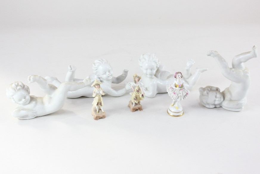 Four blanc de chine porcelain models of cherubs in various poses, together with a miniature model of