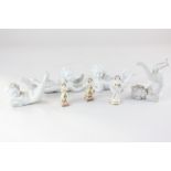 Four blanc de chine porcelain models of cherubs in various poses, together with a miniature model of