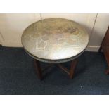 An Eastern decorative circular brass topped occasional table on folding four leg stand, 60cm