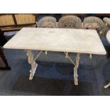 A white painted cast iron garden table with unattached rectangular marble top on pierced baluster