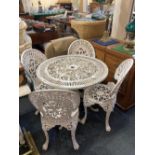 A white painted cast iron circular garden table, pieced scroll top on three cabriole legs with