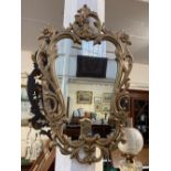 A modern cartouche shaped wall mirror with gilt pierced scrolling frame, frame 91cm by 58cm