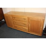 An Ercol 'Windsor model' pale wood sideboard, with three central drawers and cutlery tray flanked by