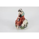 A Naples porcelain figure by Cortese, a woman seated beside a goat, 18cm high