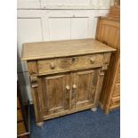 A pine cabinet, with drawer over two panel doors enclosing cupboard, on turned feet, 81cm