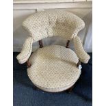 A Victorian upholstered salon chair with floral button upholstered back and padded arms, on turned