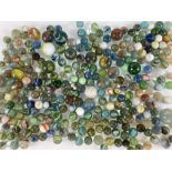 A collection of glass marbles, some clear with internal swirls, others opaque, with glass droplets