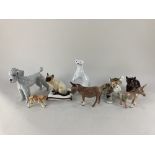 A Goebel porcelain model of a poodle, four Beswick porcelain models of a Siamese cat sat on a