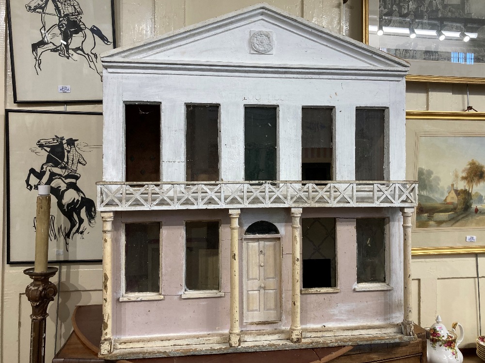 A Regency style white painted wooden dolls house, the hinged facade with pointed pediment, nine