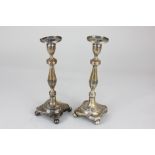 A Pair of Portuguese silver table candlesticks, shaped square bases on ball feet with faceted