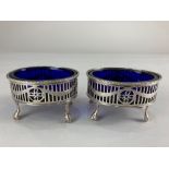 A pair of George III silver and blue glass salts, London 1775, (marks worn) of oval form with