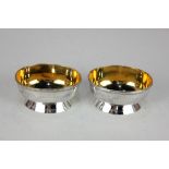 A pair of Victorian silver gilt oval salt cruets, with beaded borders and engraved swag