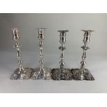 A pair of Elkington & Co silver plated column candlesticks, with embossed scrolling design, together