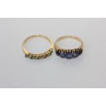 An emerald and diamond half hoop ring in 18ct gold, and a sapphire five stone ring set with