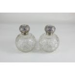 A pair of George V silver lidded cut glass globular scent bottles, maker J H Worrall, Son & Co