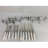 A set of six Mappin & Webb silver plated mother of pearl handled dessert knives and forks, and two