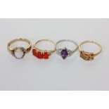 An opal and diamond ring in 9ct gold, an amethyst ring, a fire opal ring and a three stone ring