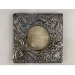 A Chinese white metal photograph frame, of square form, with embossed design of two dragons, the