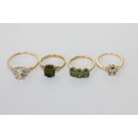 A peridot three stone ring, and three other gem set rings