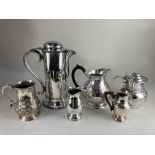 A large silver plated covered jug, a smaller covered jug with embossed design, three silver plated