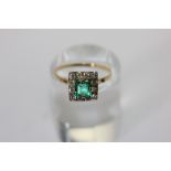 An emerald and diamond square cluster ring