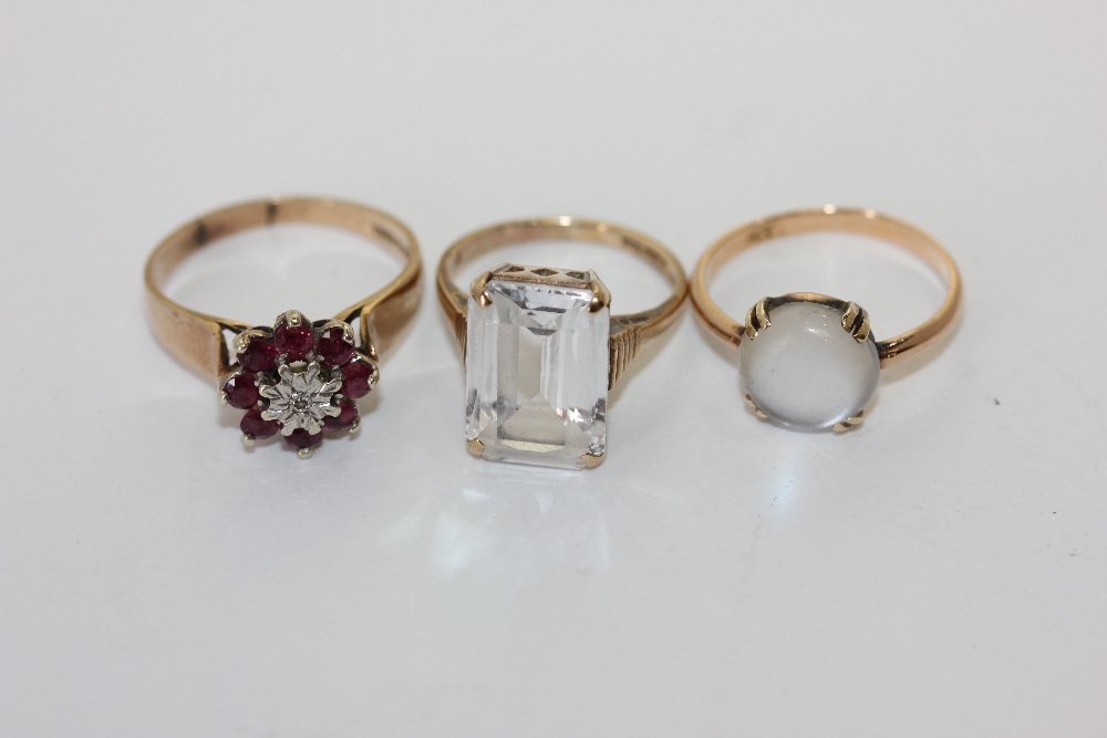 A ruby cluster ring, a moonstone ring and a white quartz ring