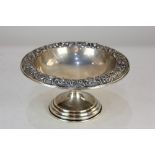 An American sterling silver pedestal bowl, with floral embossed border, stamped S Kirk & Son,