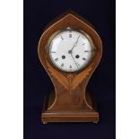 An Edwardian inlaid mahogany waisted mantle clock, the circular 4 1/2 inch diameter enamel dial with