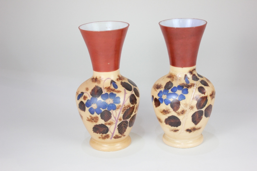 A pair of Victorian milk glass vases, of baluster form, decorated with blue flowers, on brown