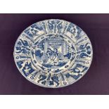 A Chinese blue and white porcelain dish, depicting seated men and women in a garden, 31cm diameter