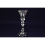 An 18th century Newcastle light baluster wine glass, with funnel bowl on a knop over a beaded