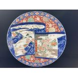 A large Japanese porcelain Imari charger, decorated with a scrolling design depicting a lion amongst