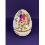 A Herend porcelain egg shaped trinket pot, decorated with flowers, fruit and vegetables, on white