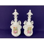 A pair of Continental porcelain bottles and stoppers, each with handpainted floral design within