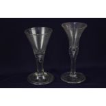 Two 18th century wine glasses, one with drawn funnel bowl, with a tear stem, on domed and folded