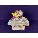 A Sitzendorf porcelain figure group of a lady and a gentleman, the lady playing the piano, 14.5cm