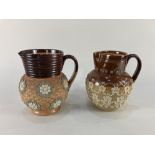 Two Doulton Lambeth pottery jugs, one with overlaid floral design by Annie Partridge, the other with