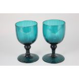 A pair of 18th century green glass goblets, with cup shaped bowls, and inverted baluster stems on