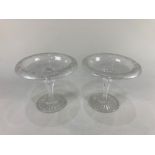 A pair of circular glass bon bon dishes with trailing vine leaf border, on baluster stems and