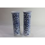 A pair of Chinese porcelain blue and white cylindrical vases, decorated with birds amongst flowers