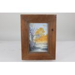 A late 19th / early 20th century glazed tile, painted with a view across marshes at sunset, tree