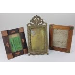 An ornate brass photograph picture frame with pierced scroll surmount and rectangular beaded border,