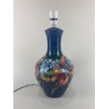 A Moorcroft pottery table lamp in the orchid pattern on blue ground, 40cm high