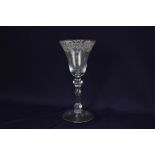 An 18th century Newcastle light baluster wine glass, the large round funnel bowl with engraving,