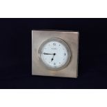 A modern silver travel clock, circular white dial marked R J Carr set in square 925 silver frame