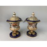 A pair of small Davenport porcelain Campania urns and covers, each on triform lion feet and circular