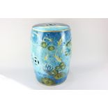 A glazed ceramic garden seat, barrel shaped, decorated with fish swimming amongst water lilies, 47cm