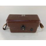 A field telephone, with rotary dial, in hard plastic case with leather strap, possibly military,