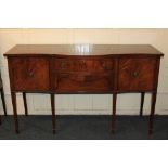 A Sheraton style mahogany sideboard banded serpentine top above two central drawers and side