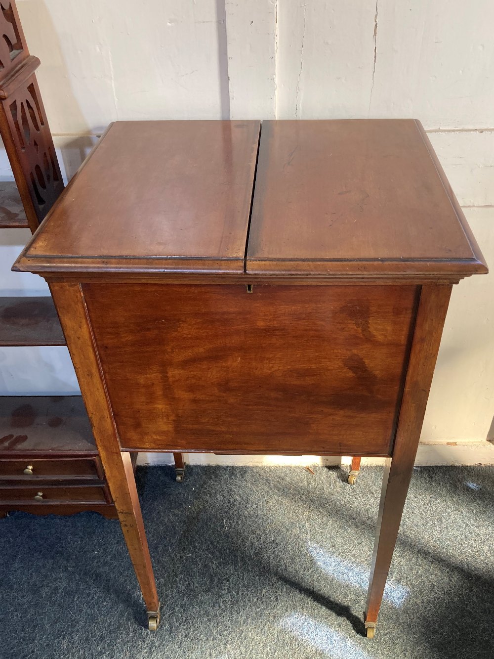 An early 20th century mahogany 'surprise' drinks table cabinet with rising top and shelf fitted with